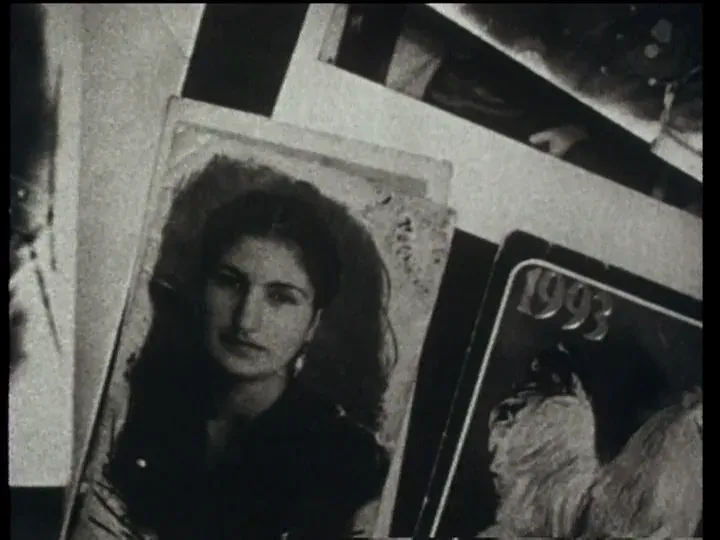 A spread of printed cards, a portrait of a young woman with long dark hair among them and one marked 1993